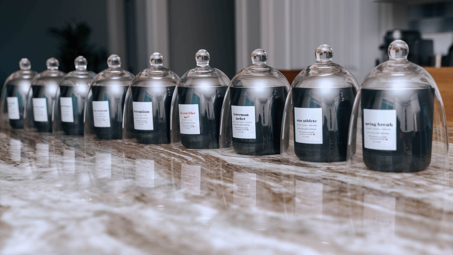 Collection of School Scents candles displayed under glass domes on a countertop